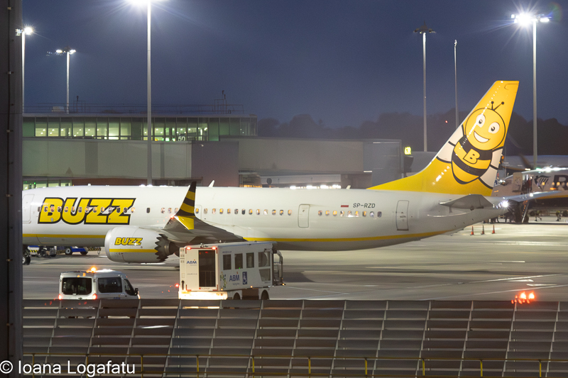 A colorful airplane awaits departure at twilight